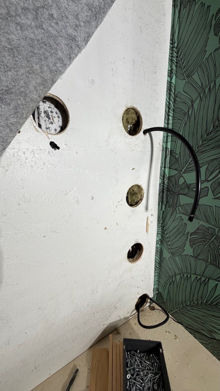 Geöffnete Wand mit vorbereiteten Bohrungen für die Leitungsführung